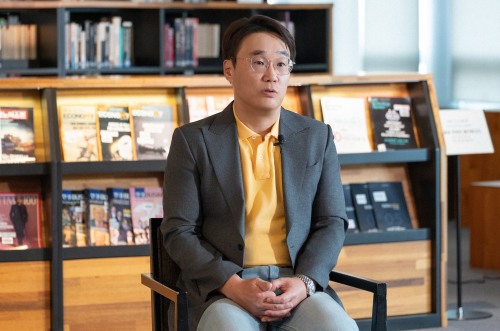 [Figure 5] 사무실 책장 앞에서 인터뷰 중인 권영준 연구소장 - AI 모델 성과에 대해 이야기하는 모습